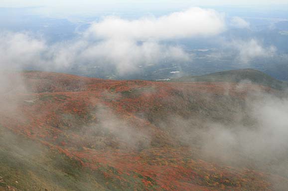 雲の間から、垣間見る紅葉の写真